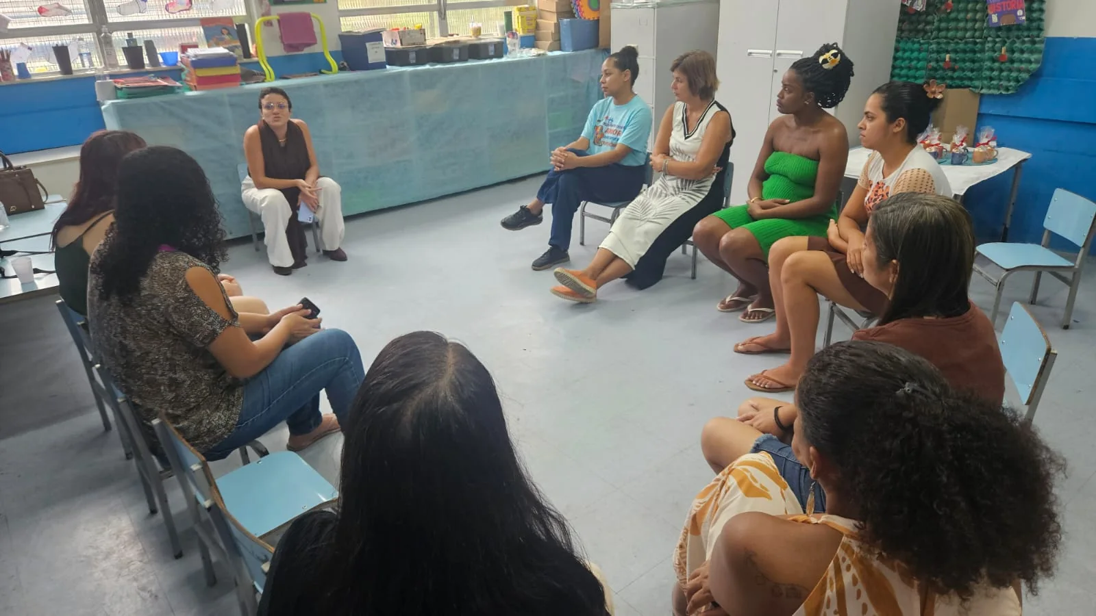 Thaís em uma roda de conversa com participantes em uma escola